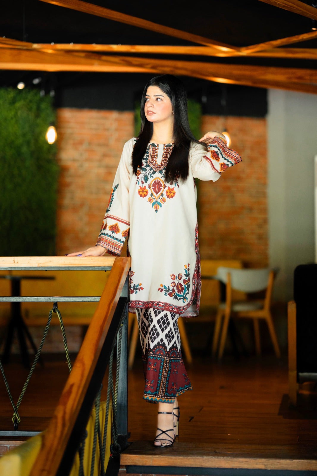 Woman in a traditional outfit standing in a casual indoor setting House of Beenora |  Best women clothing brand in Pakistan