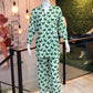 Mannequin wearing a green and white patterned dress in a store setting.