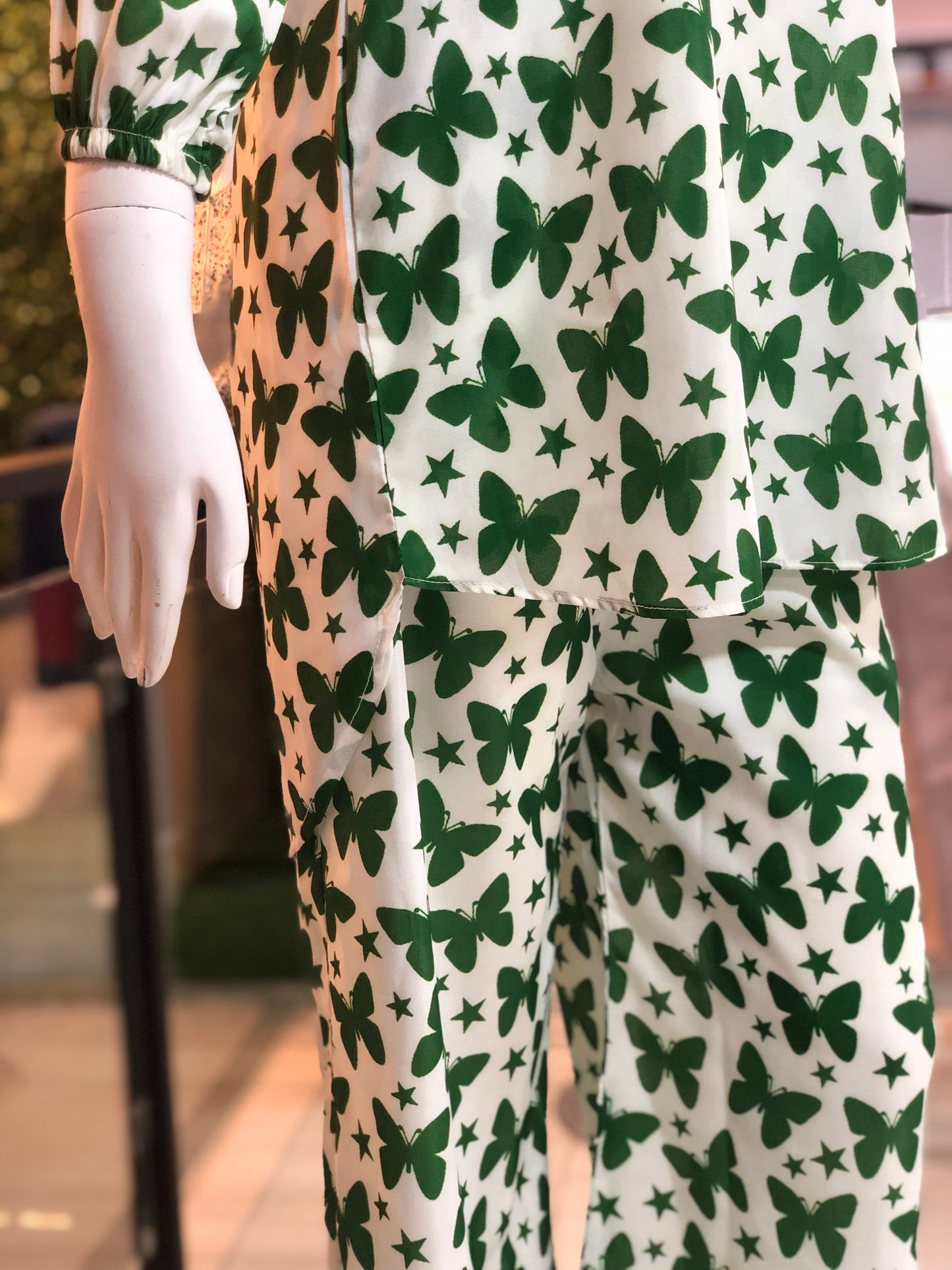 Green butterfly pattern on white pajama set worn by a mannequin.