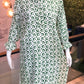 Green and white patterned dress on a mannequin in an indoor setting.