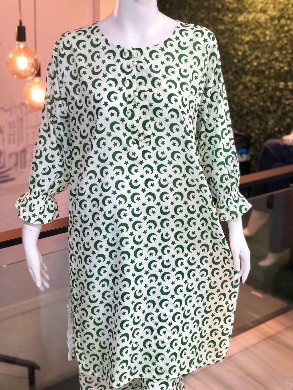 Green and white patterned dress on a mannequin in an indoor setting.