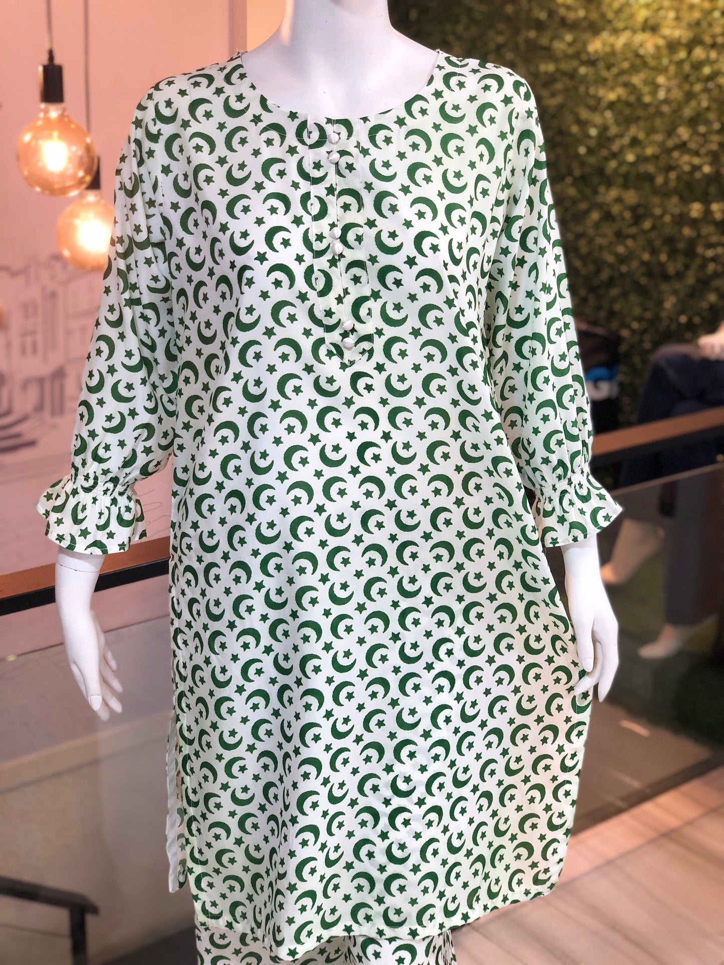 Green and white patterned dress on a mannequin in an indoor setting.