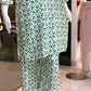 Green and white patterned outfit on a mannequin in a store setting