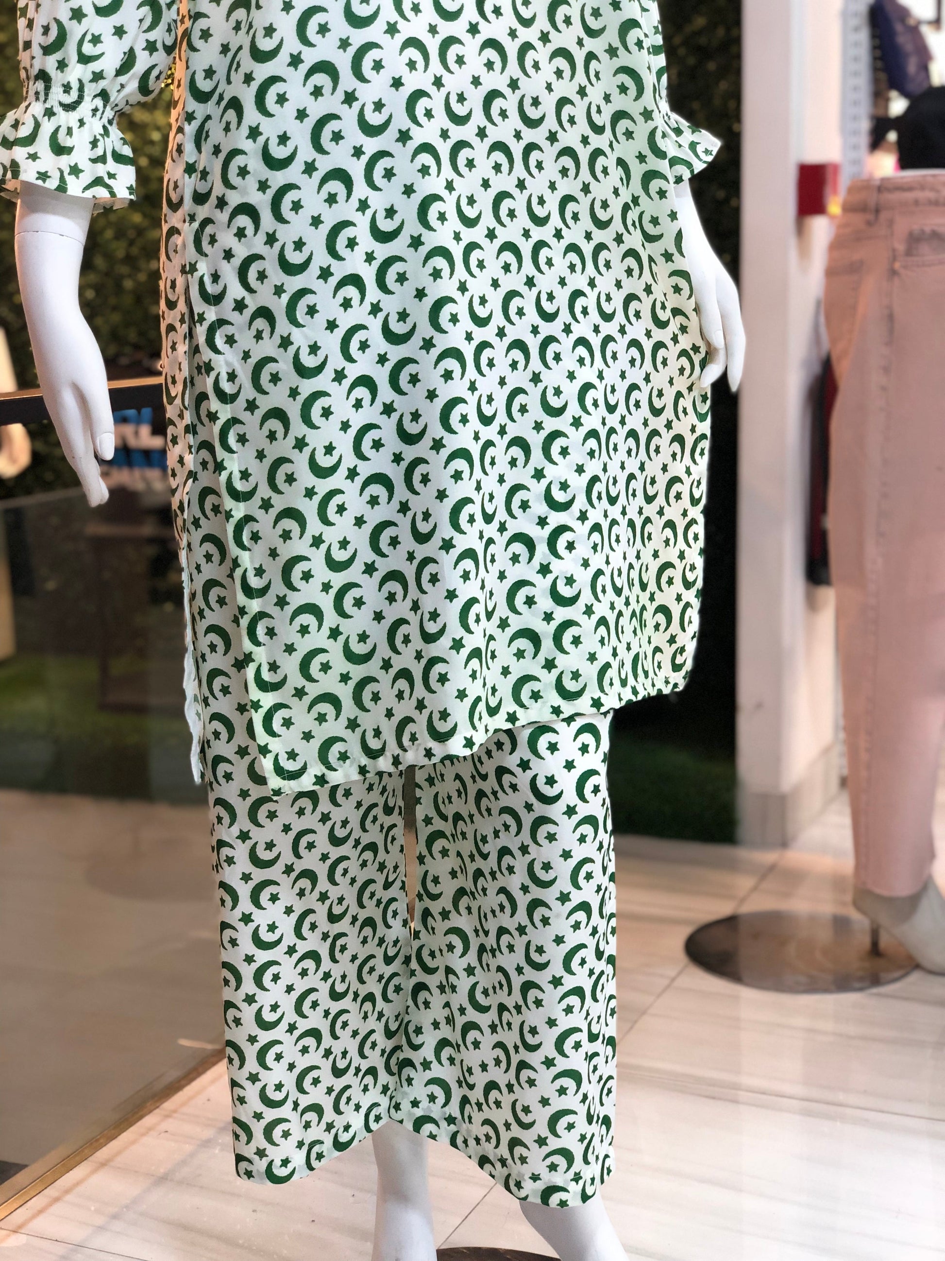 Green and white patterned outfit on a mannequin in a store setting