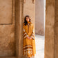 Woman in a yellow traditional outfit standing in a sunlit stone corridor. House Of Beenora | Best women clothing brand in Pakistan