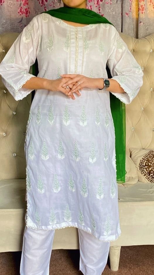 Person wearing a white embroidered kurta with green dupatta on a floral background
House of Beenora |  Best women clothing brand in Pakistan