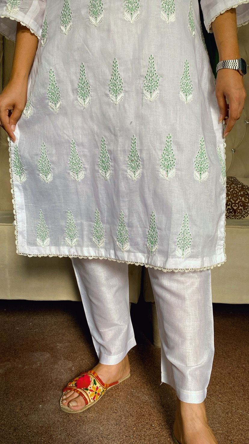 Person wearing a light-colored kurta with green patterns and white pants House of Beenora |  Best women clothing brand in Pakistan