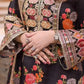 Close-up of a person wearing a black embroidered outfit with colorful floral patterns. House Of Beenora | Best women clothing brand in Pakistan