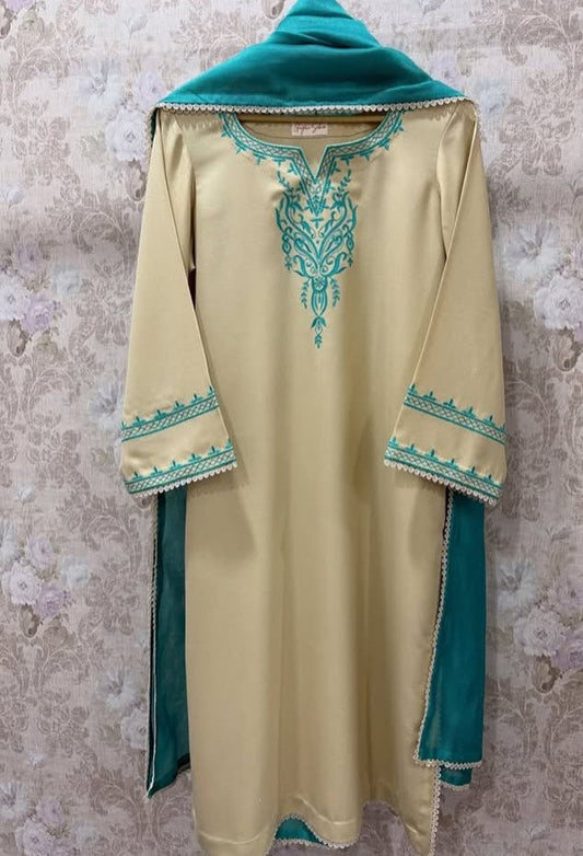 Beige dress with green embroidery on a textured wall background