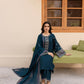 Woman in a blue traditional outfit sitting on a green couch in a room with a wooden window.
