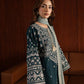 Woman wearing a traditional outfit with intricate patterns in a warm-toned room.